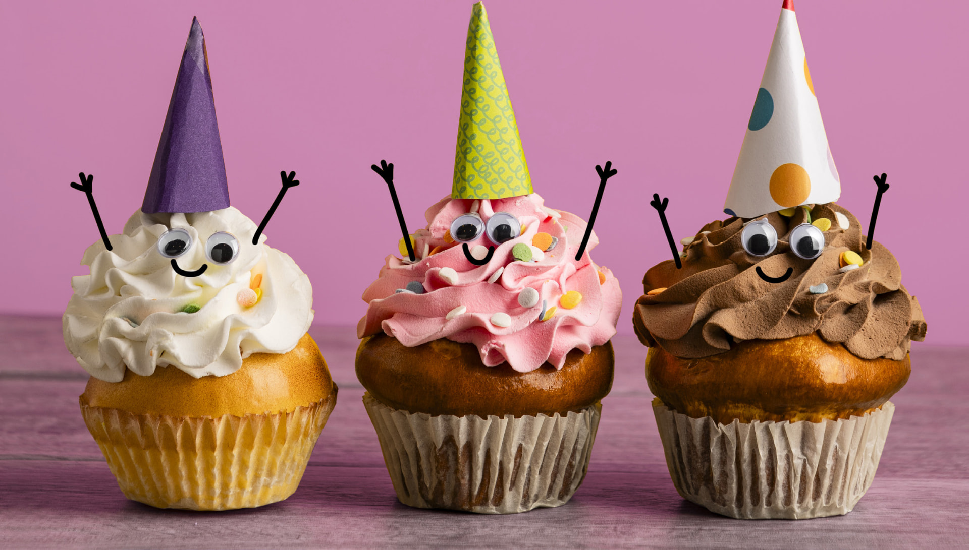 Tre cupcakes med festhatte og bevægelige øjne